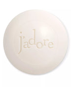 Round white bar of soap with 'j'adore' text on a white background
